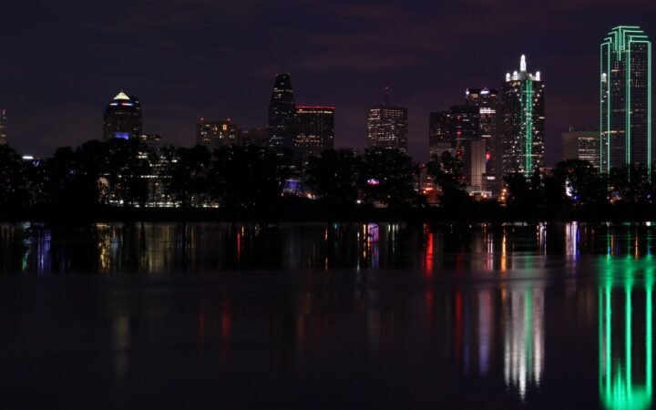 Illustrative archive photograph of Dallas’s illuminated skyline reflected across the Trinity River at night in 2015.