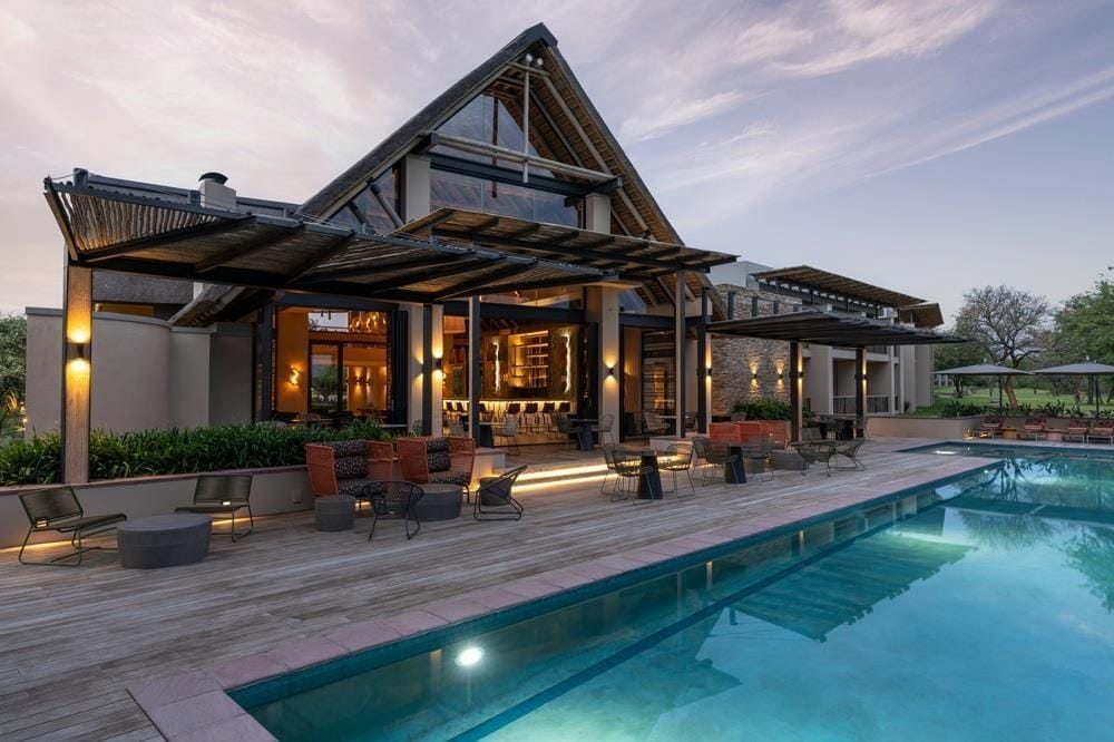 Radisson Hoedspruit pool and restaurant terrace at dusk.