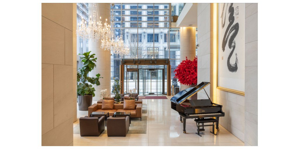 Lobby at Hyatt Vancouver Downtown Alberni with seating, chandeliers, a grand piano and tall windows.