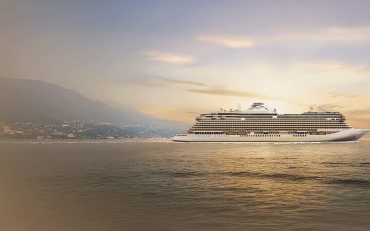Official rendering of Seven Seas Prestige sailing past a mountainous coastline at sunset